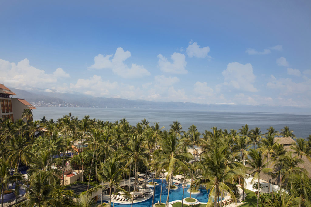 View of the resort's palm grove and Bay of Banderas from balconies at the Westin Puerto Vallarta Resort. Photo c. Westin Resort & Spa, Puerto Vallarta.