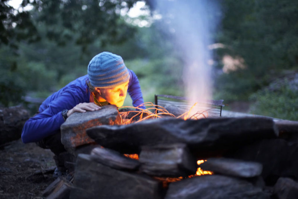 Starting a fire in the wood the old-fashioned way with kindling.