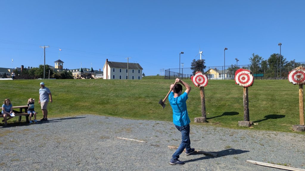 Family watches man in axe-throwing competition at the Mountain View Grand in the White Mountains.