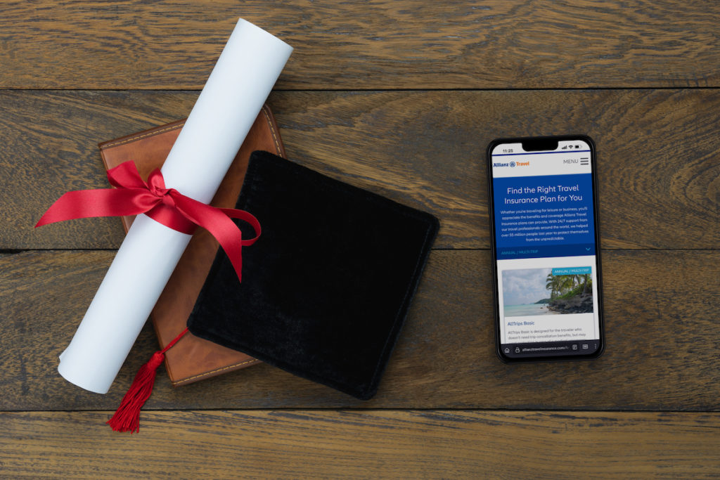 College diploma and cap with cellphone.