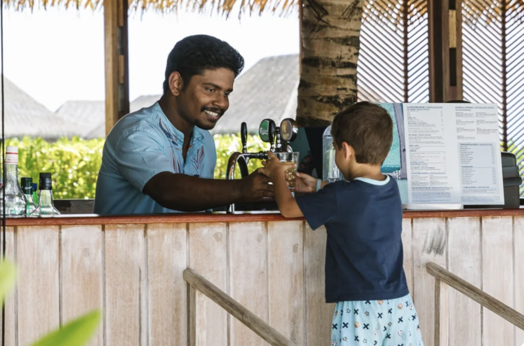 Boy carries a drink away from a bar at Club Med Cancun resort. Photo c. Club Med