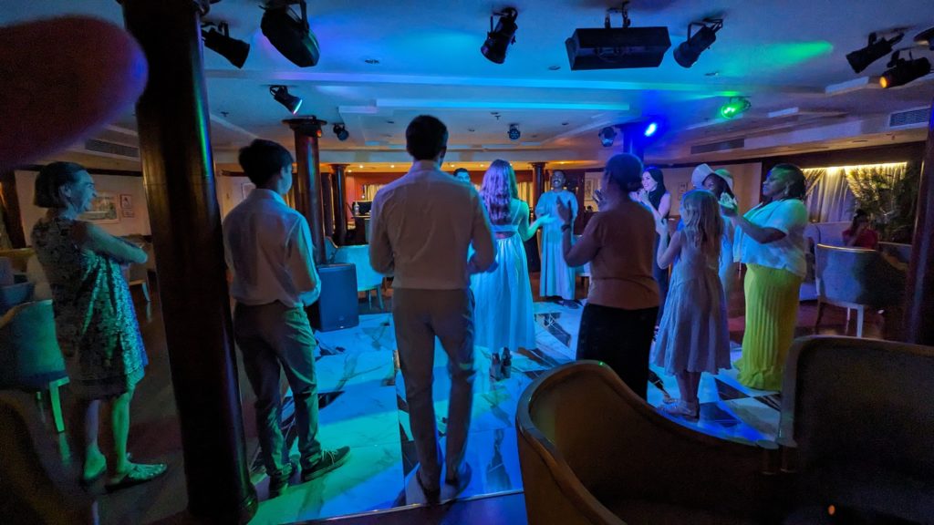 Nile River cruise guests participate in a Nubian dance performance in the ship's lounge.