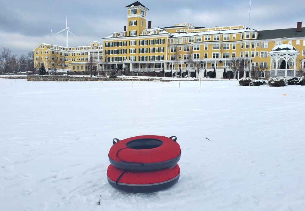 The Mountain View Grand Spa Resort in winter with inner tubes poised for sledding on the front lawn. c. Heather Brown for MVG.