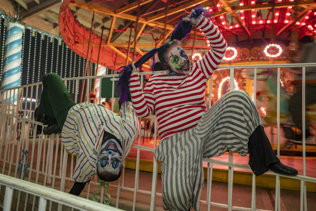 Clowns and ghouls play on the thrill rides and around concession stands at Six Flags parks for the Halloween holidays.