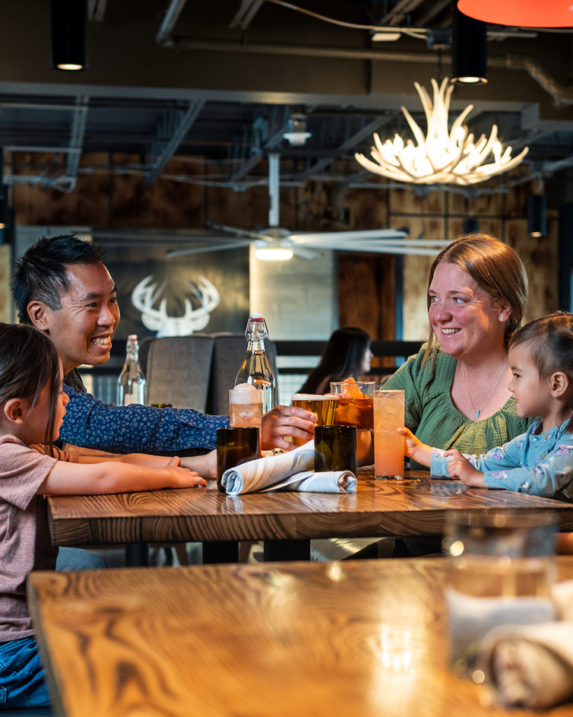 Communcal family dining on a snow sports vacation at Gravity Haus. Photo c. Gravity Haus