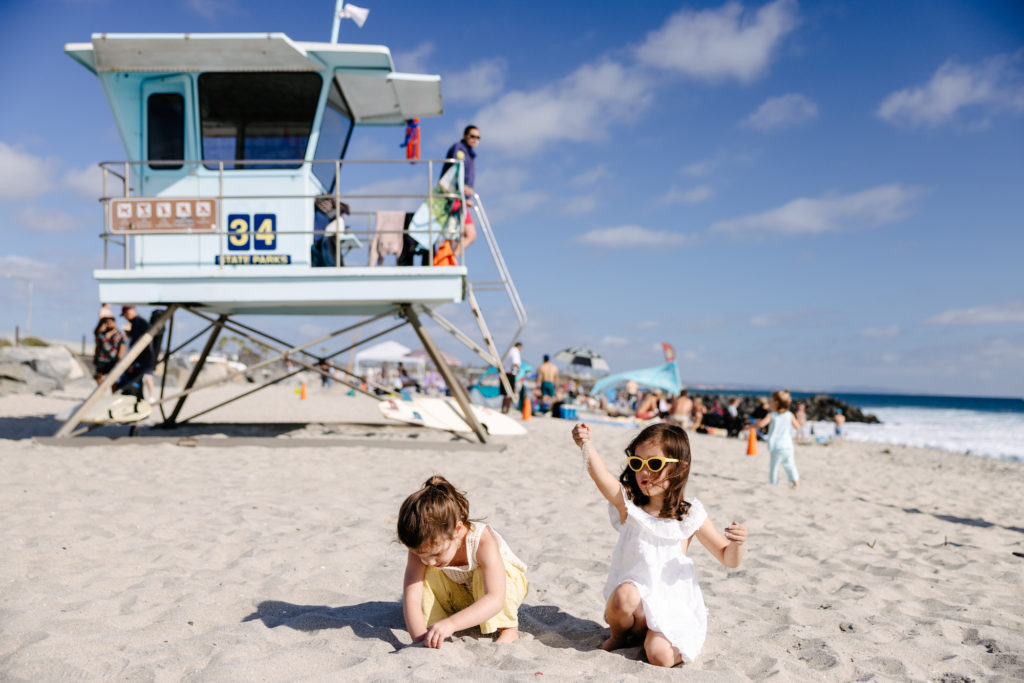 Girls playing by a lifeguard stand at Tamarack Surf Beach, Carlsbad, CA. Photo c. VisitCarlsbad