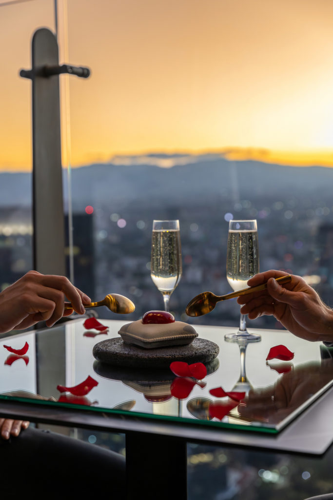 Couple enjoys an appetizer and champagne at the Sofitel Mexico City Reforma overlooking the Plaza del Angel. Photo c. Sofitel Mexico City Reforma