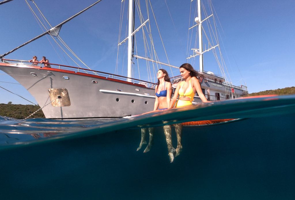 Girls sunbathe on paddleboard in one of the best places to sail in Croatia in the Adriatic.