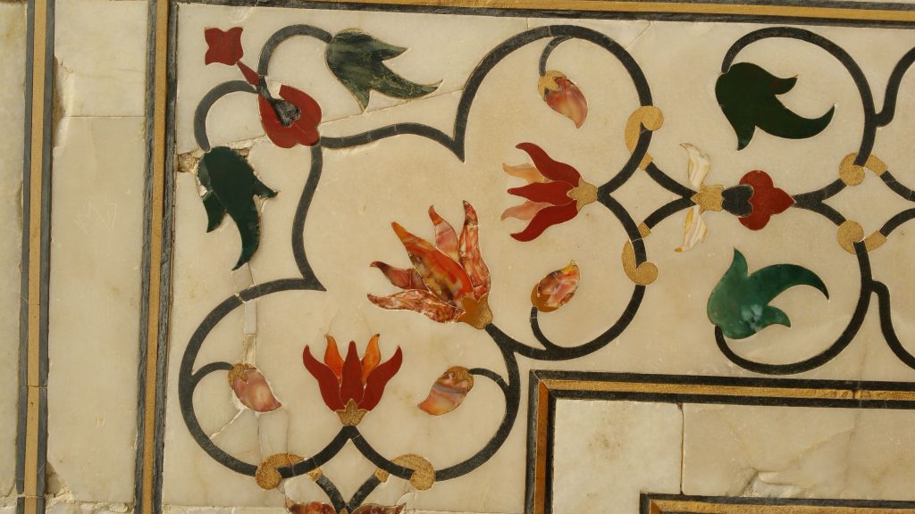 Close up of Taj Mahal wall with flowers made from agate, carnelian and jade inlaid in marble.