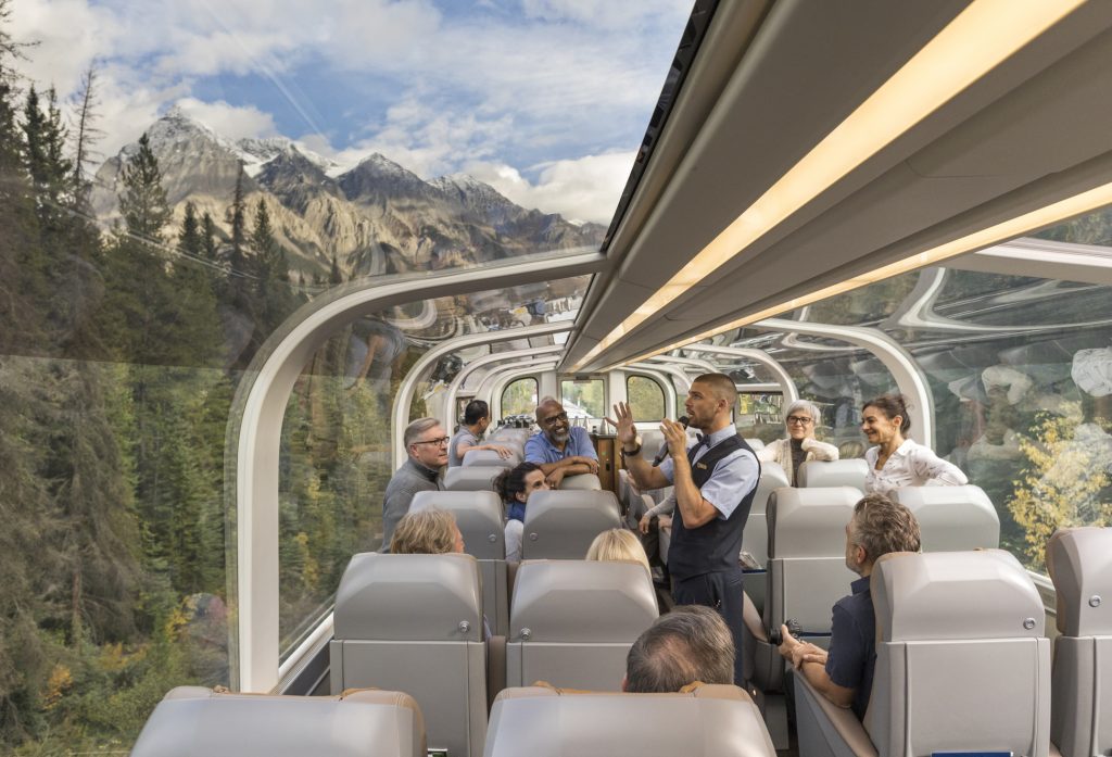 Rocky Mountaineer host describes Canadian wilderness in Gold Leaf class train car.