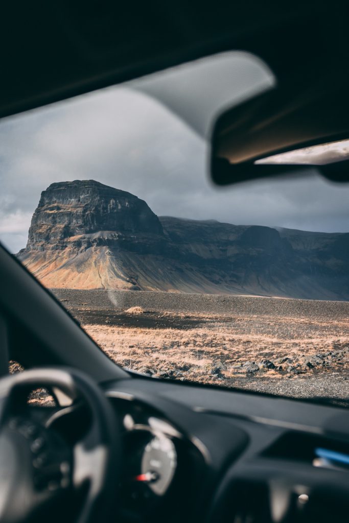 Gray mountain and desert landscape seen through windshield