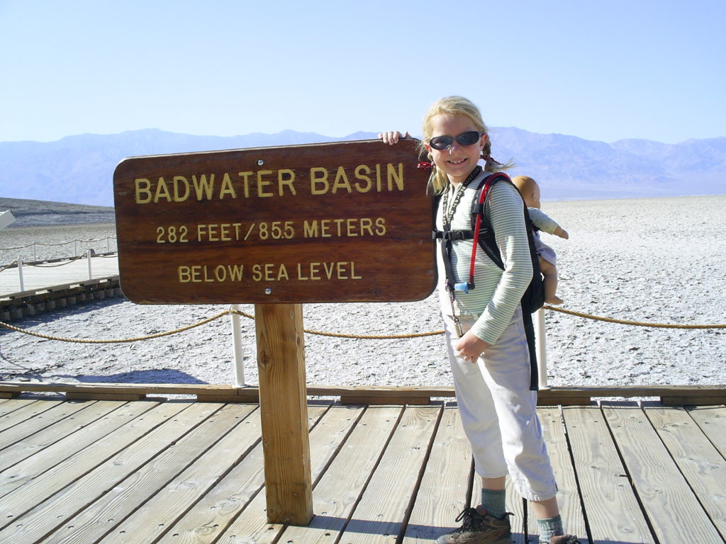 Girl at entry sign at Badwater, Death Valley National Park