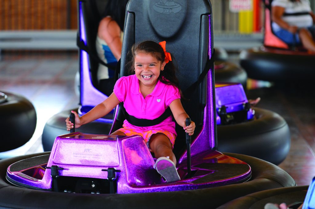 Young girl dresssedf in pink on a bumpber car. Photo c. Magic Mountain Fun Center.