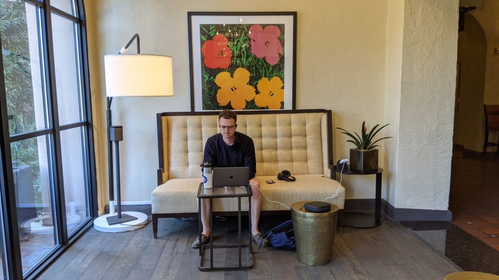 Man working at computer while seated on couch.