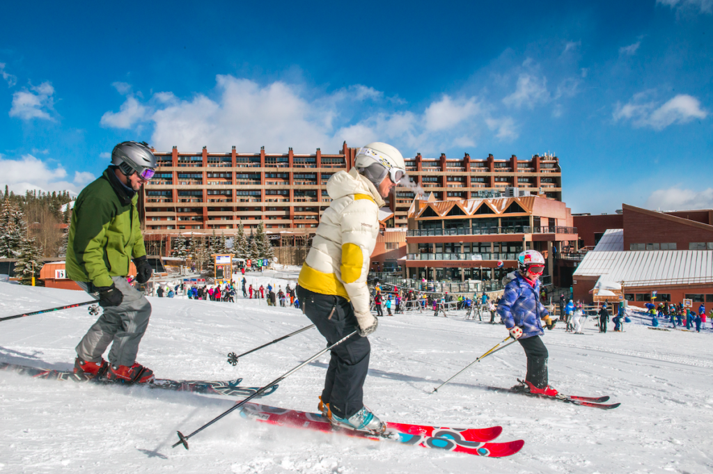 Parents taking child out on skis outside Beaver Run Resort in Breckenridge, Colorado.