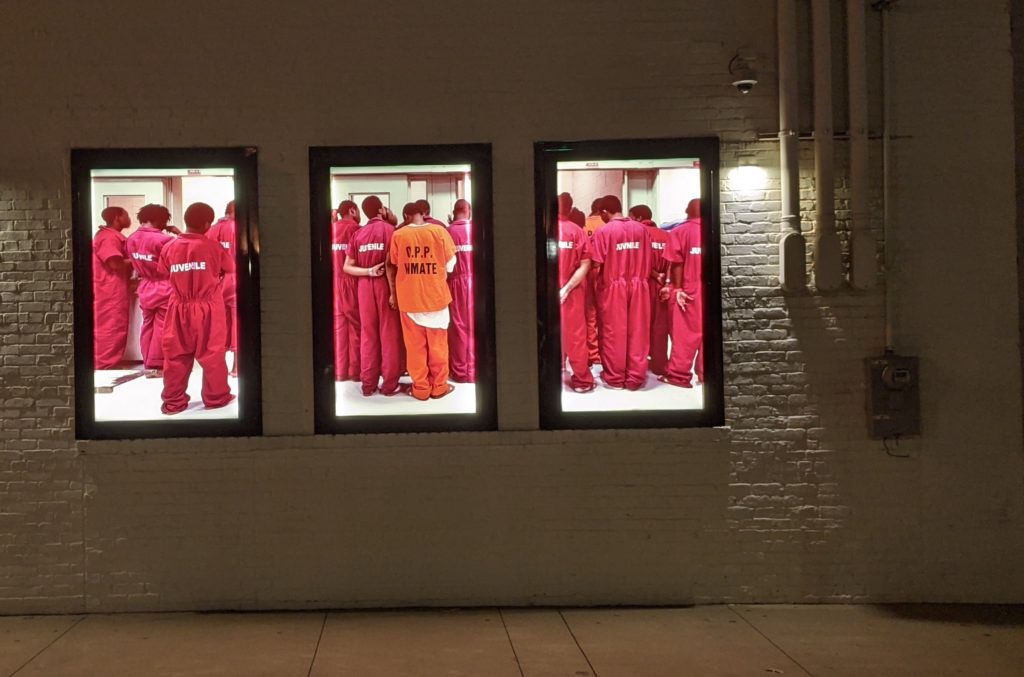 Video walls of incarcerated Black men outside the EEJI: Legacy Museum in Montgomery, Alabama.