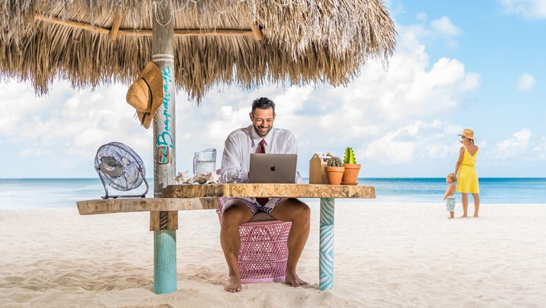 Dad working from beach palapa at Boardwalk Boutique Hotel Aruba on Palm Beach.