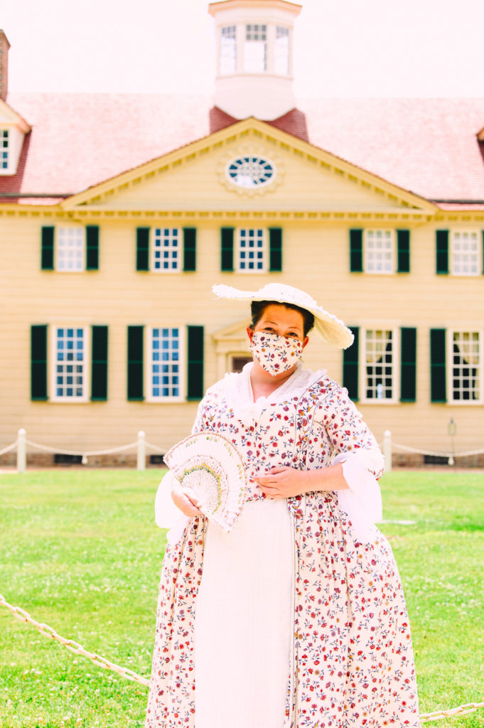 Mount Vernon re-enactor in costume and face mask.