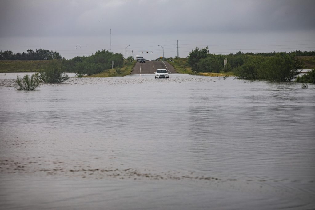 Single car stuck on flooded street after hurricane.