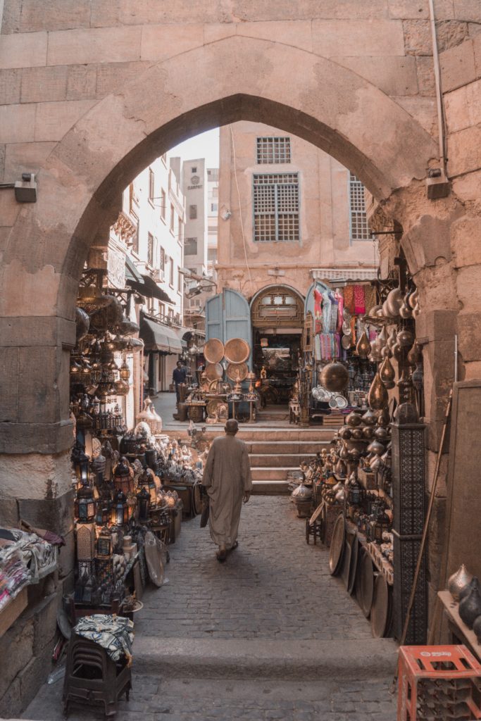 Man walks through the stall of a copper vendor in the Cairo souk.