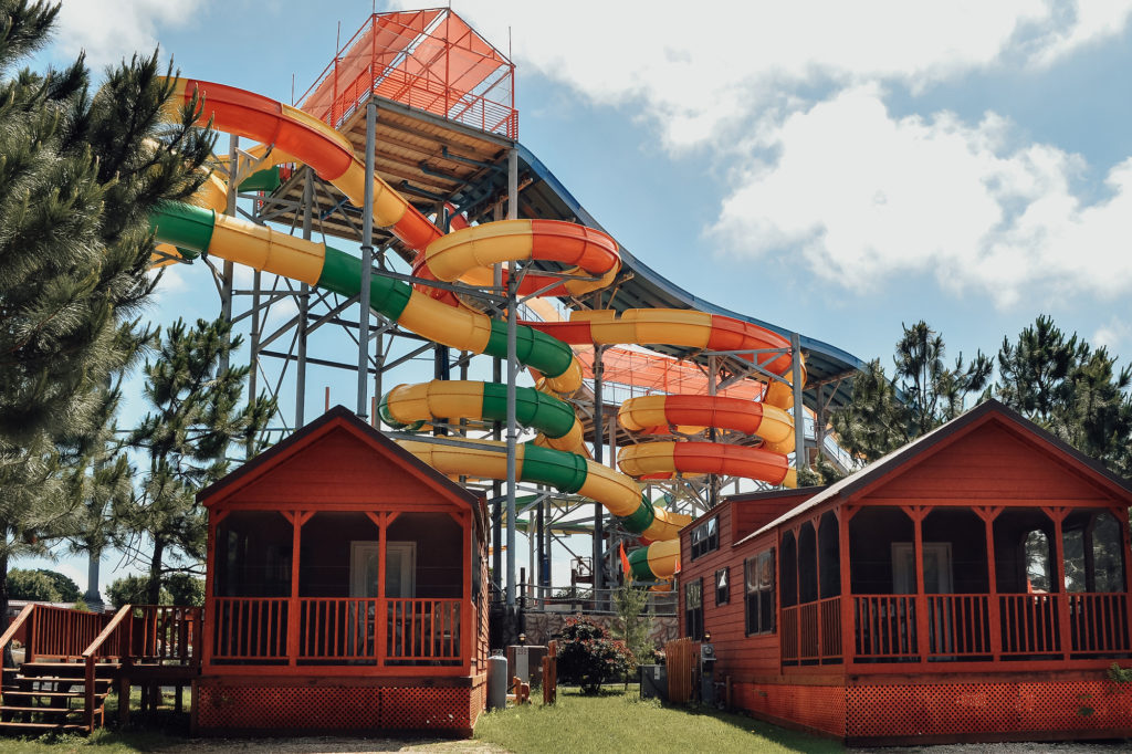 Rustic cabins and a large waterslide at Jellystone Park Camp-Resort in Burleson, Texas