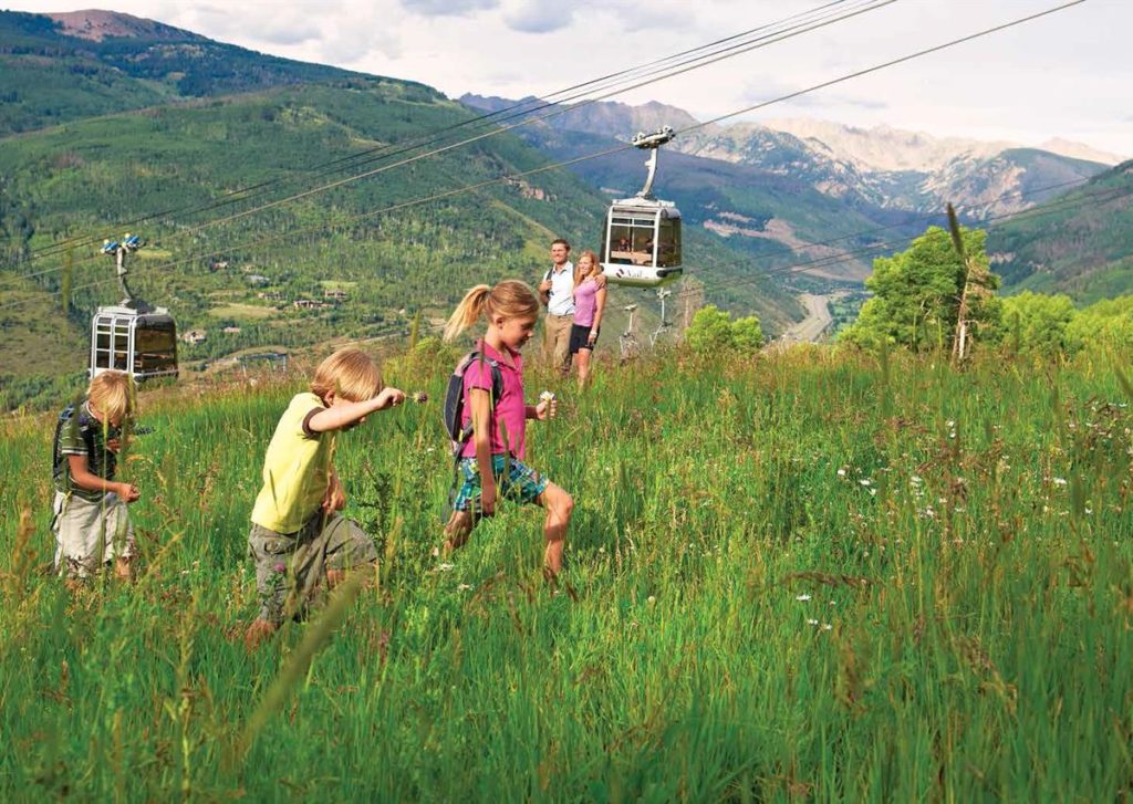 Kids hiking while adults look on at Vail, Coloraod.