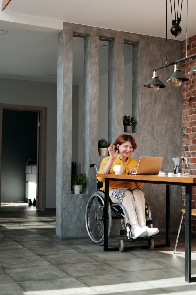 Girl in wheelchair talking to someone via computer screen