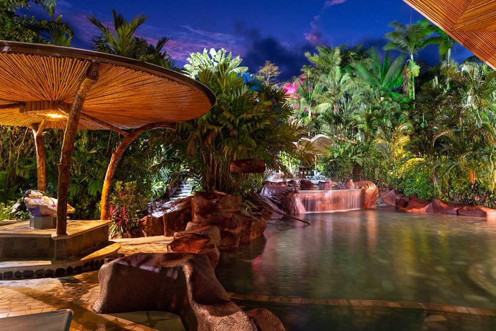 Shaded table and lounge chairs overlook Baldi Hot Springs in Costa Rica