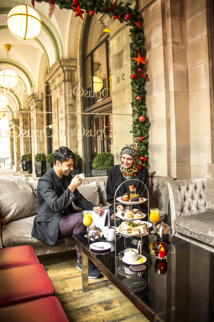 A young Arabic couple at the The Radisson Blu hotel in Manchester, a luxury hotel. Taking English afternoon tea at Opus. Colonnades.