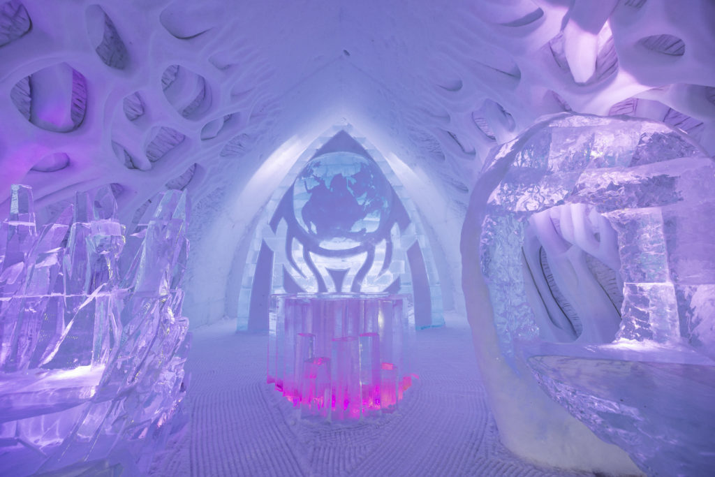 A stunning illuminated bar made out of ice is a centerpiece of the Ice Hotel at Valcariter in Quebec. Photo c. Village Vacances Valcartier