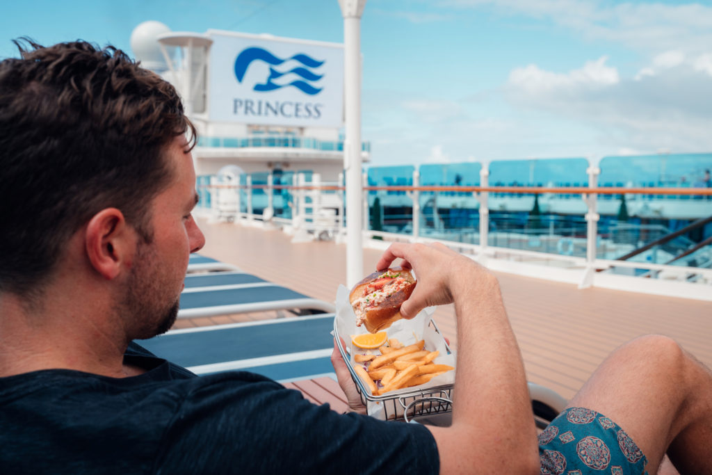 Man eating a lobster roll aboard a Princess cruise ship in Alaska.