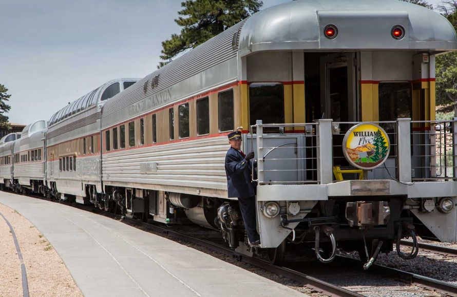 Conductor aboard back of Grand Canyon Railroad's sightseeing train.