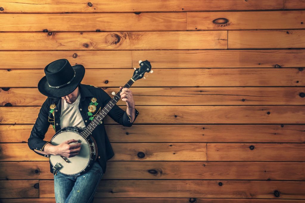 A male musician playing a banjo.