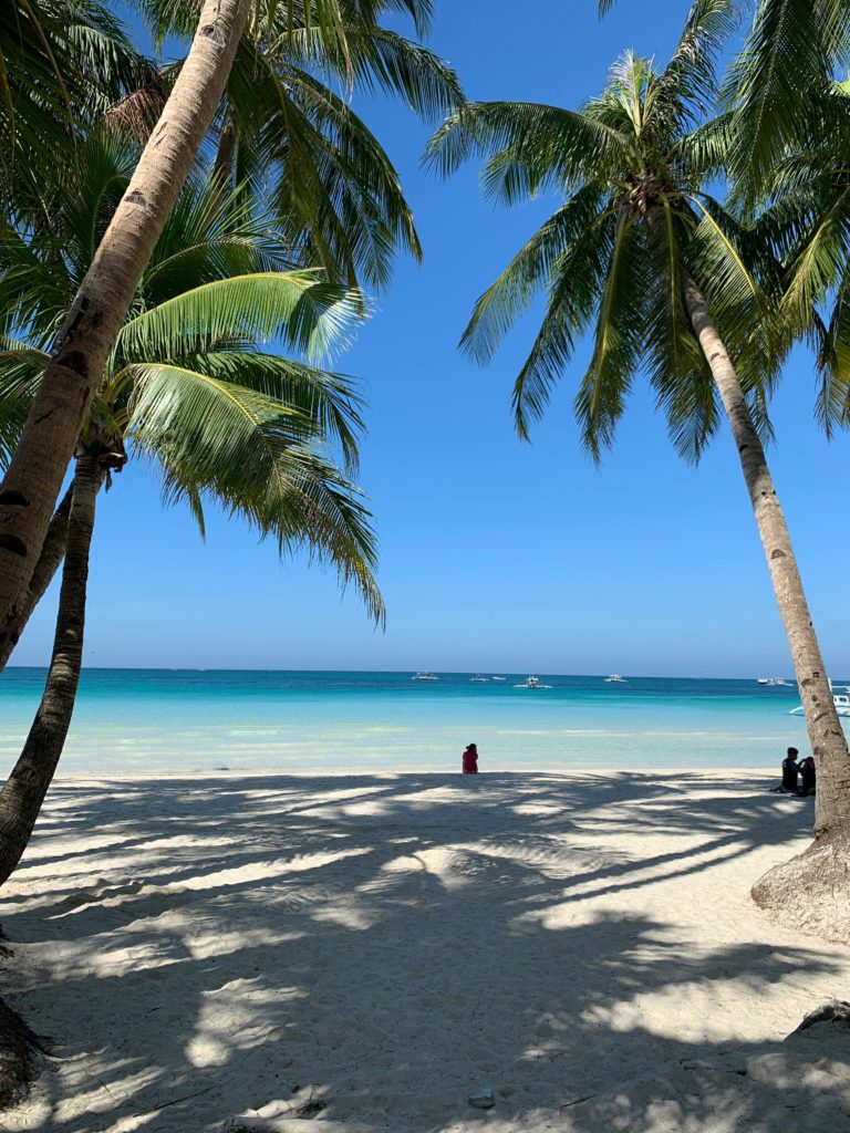 An adult sitting at the beautiful coastal beach of Mexico. Photo by Jasmine Ortega for pexels.
