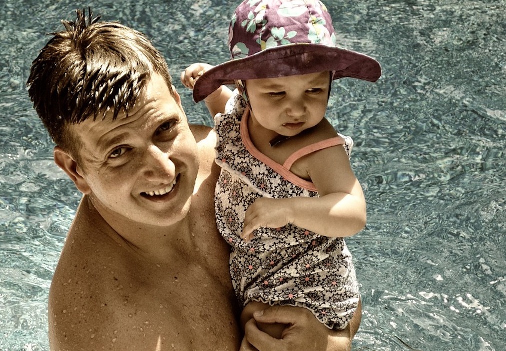 Father teaches baby how to swim in a lake. Photo c. mellaviews for pixabay