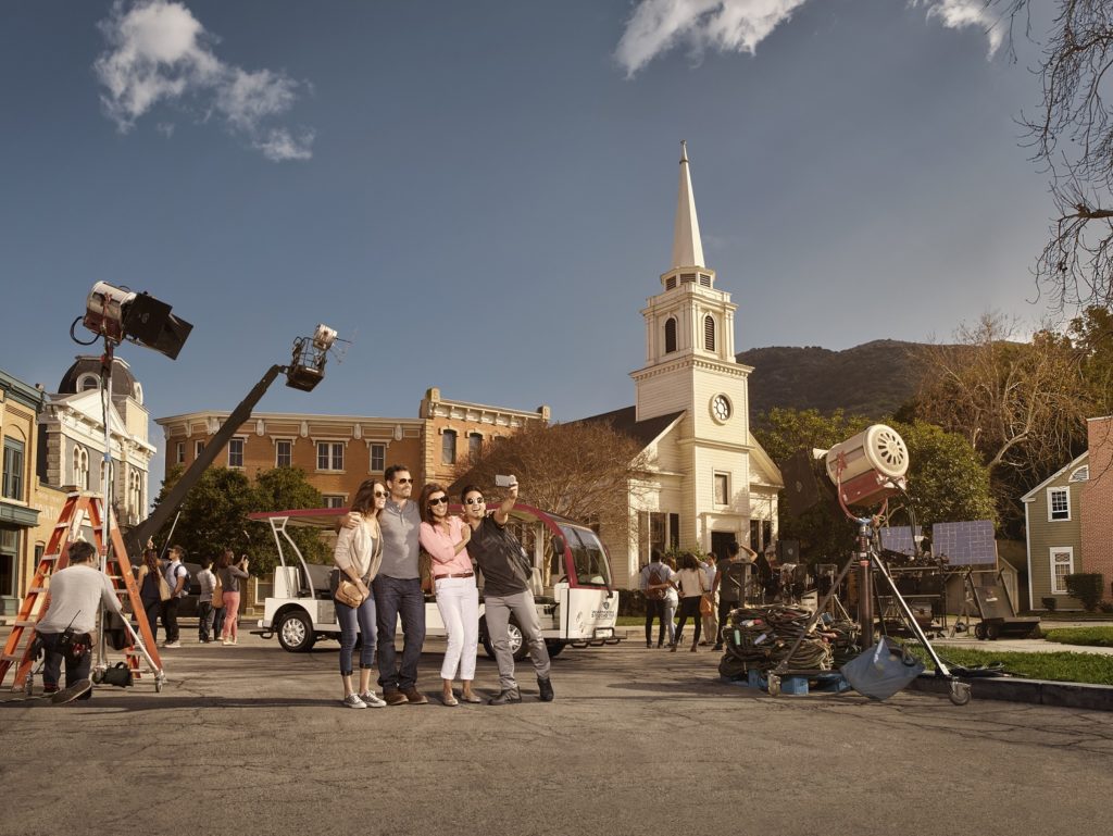 Visitors pose for a photo on the Midwest backlot at the Warner Bros. studio tour in Burbank.