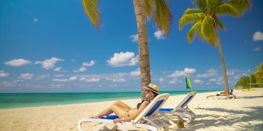 Woman in bathing suit on a beach chair at one of the Viva Wyndham all-inclusive resorts.