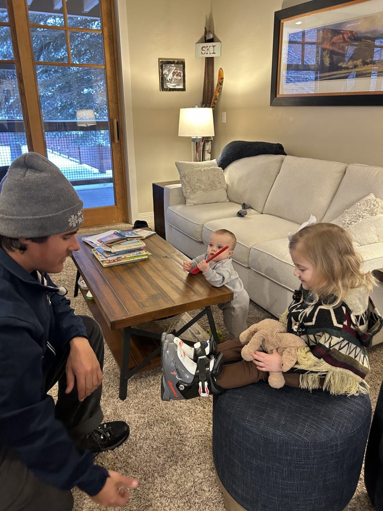 Skis on the Run technician fits toddler for ski boots at the condo. Photo c. Laura Sutherland