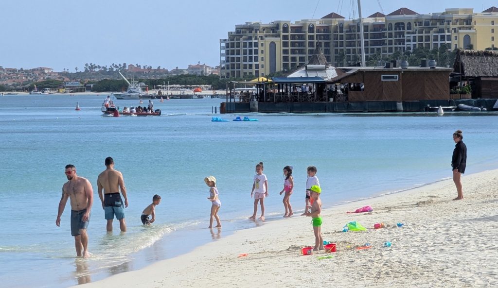 The busy beach scene and multistory hotels of Aruba's Palm Beach.