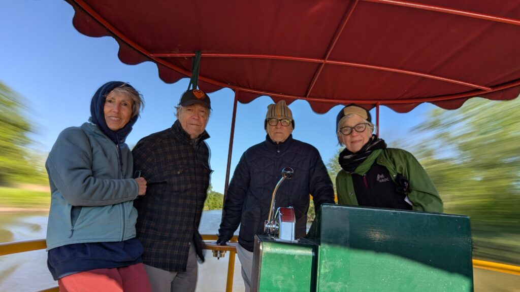 Two couples on the stern deck pilot a rental barge on the Erie Canal.