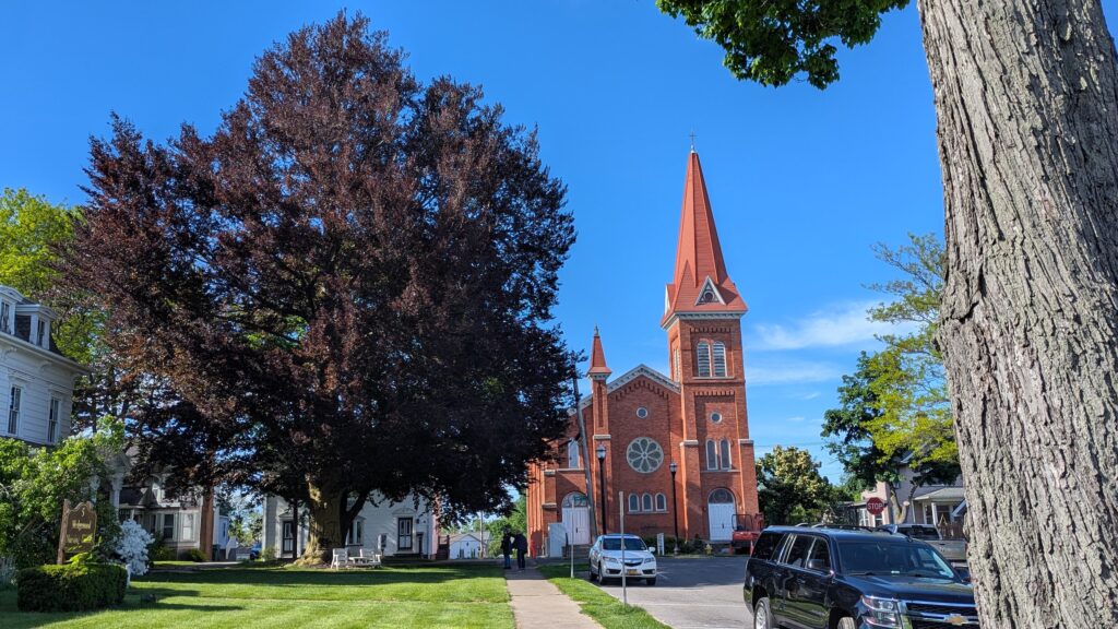 Historic white homes and red brick church in Spencerport, New York.