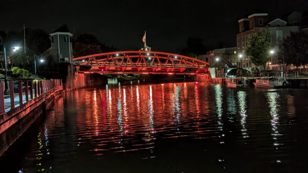 Nightime view of the historic Fairport Lift Bridge illuminated in red lights.