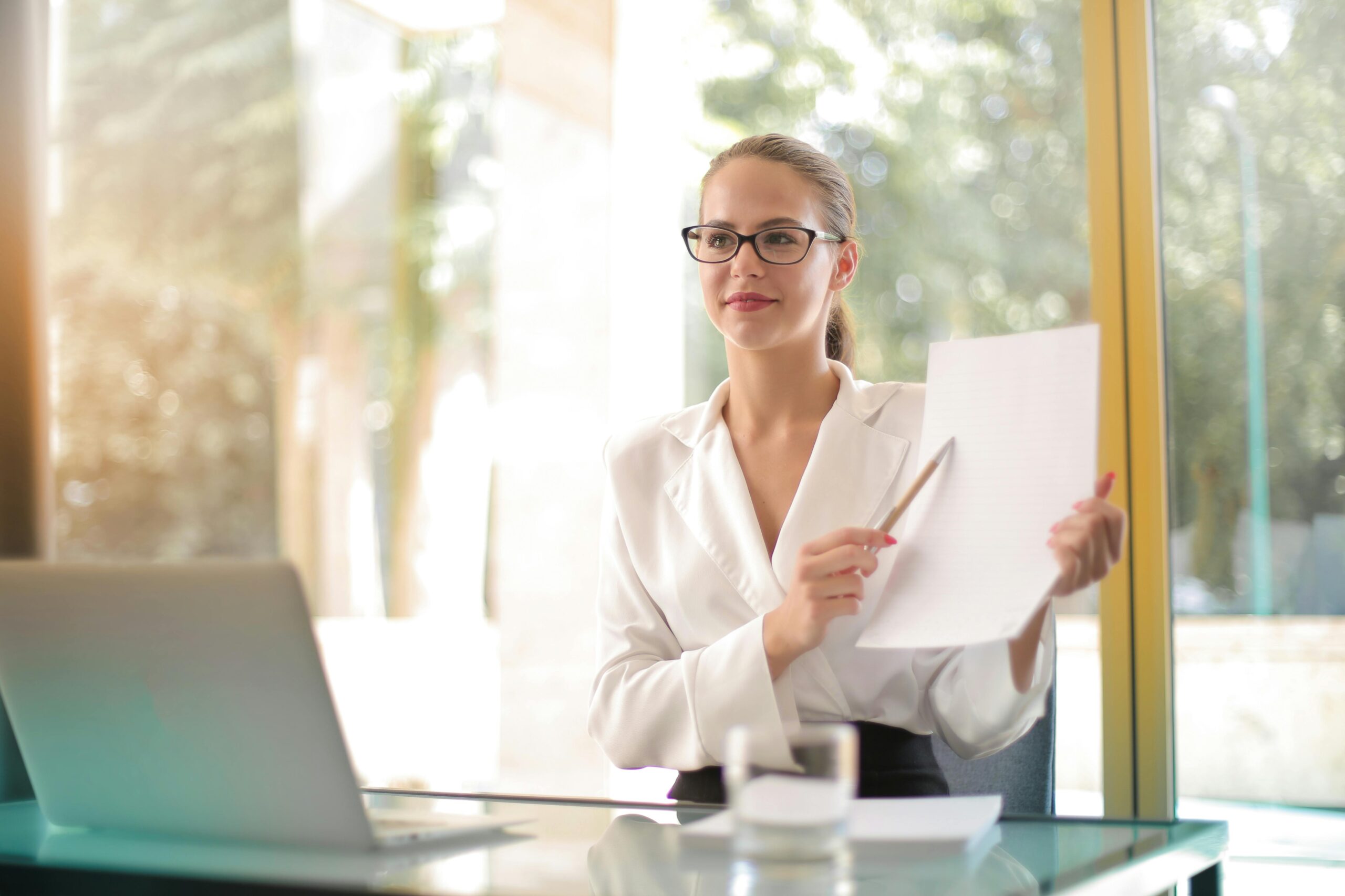 Woman holds up papers being notarized. Photo c. Andrea Piacuadio via pexels