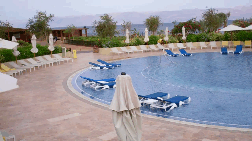 Circular pool, with sun loungers along the shallow border, waits for all inclusive resort guests to arrive and take their places.