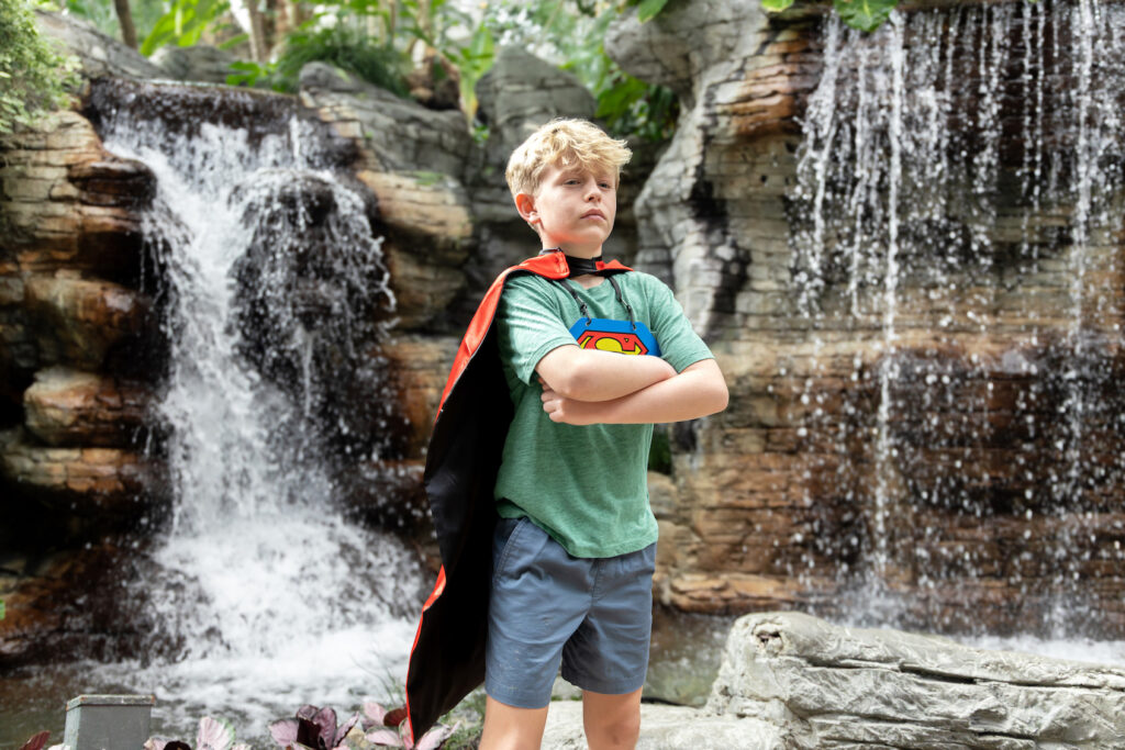 Young boy poses in a Superman cape in the atrium of the Gaylord Opryland in Nashville, Tennessee as part of their family entertainment summer promotion.