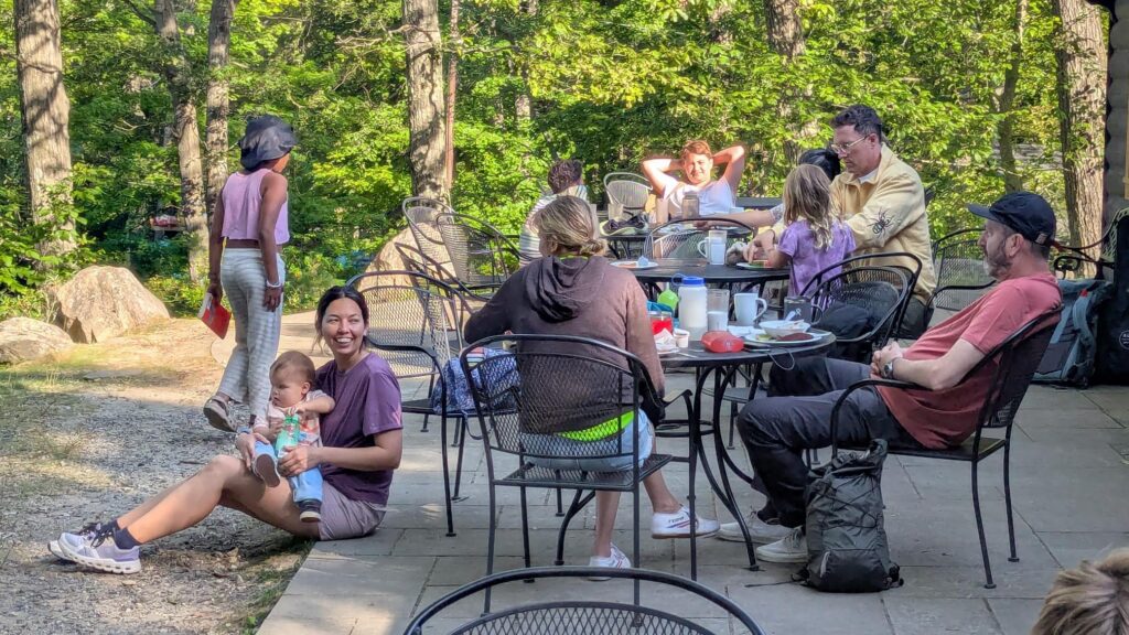 Families dining outdoors by the mess hall at the AMC Harriman Outdoors Center.