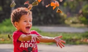 Boy enjoying throwing leaves on a fall getaway. Photo c. Gusstavo Santana for pexels