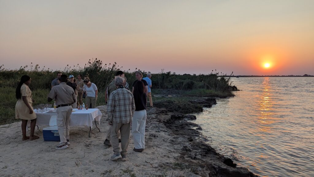 A Zambezi River Sundowner: cocktails and sunset views with our CroisiEurope river safari group. 