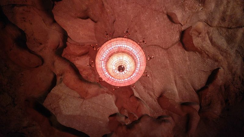 A Giant Chandelier Bolted Into The Craggy Ceiling