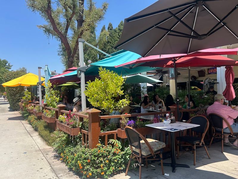 The Cheerful Yellow Umbrellas Dotting The Outdoor Patio